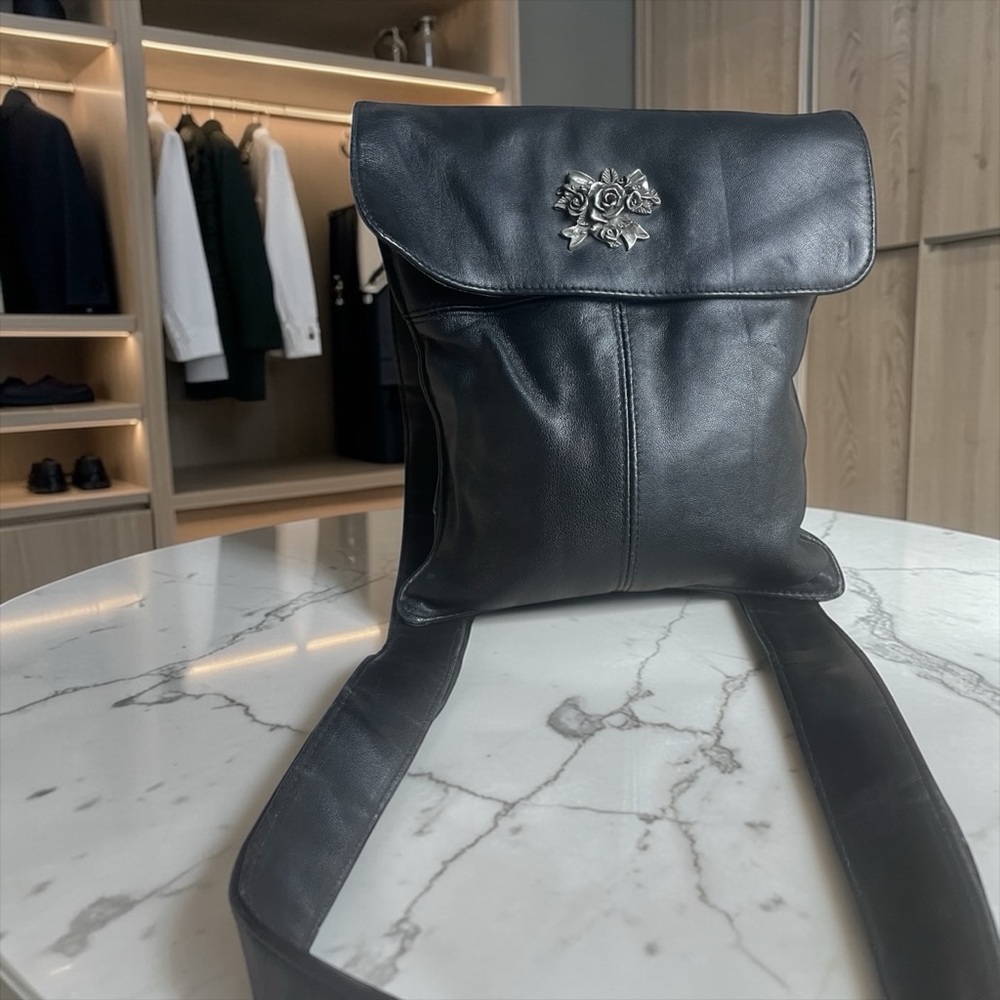 White Fox Boutique Black Leather Backpack with Silver Floral Emblem